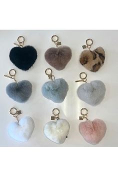 six heart shaped keychais are shown in different colors and sizes, one is black, the other is white