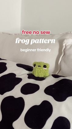 a stuffed animal sitting on top of a bed covered in black and white polka dots