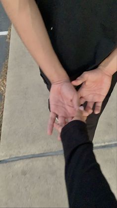 two people holding hands while standing next to each other