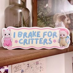 a wooden sign that says i brake for critters with two cats on it