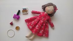 a doll, ring, and other items are laid out on a white table top