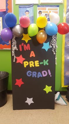 a chalkboard with balloons and confetti on it that says i'm a prek grad