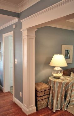 a room with a lamp, table and basket on the floor