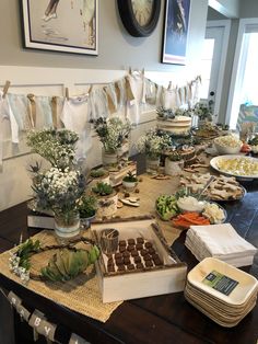 a table filled with lots of food on top of a wooden table covered in paper towels