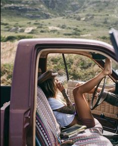 a woman sitting in the driver's seat of a truck talking on her cell phone