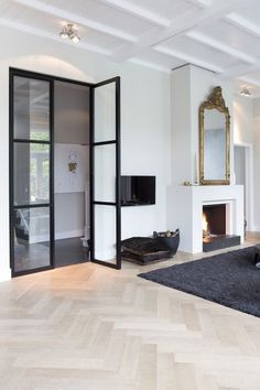 an image of a living room with white walls and black furniture on the bottom right hand corner