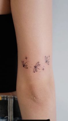 a woman's lower back tattoo with three dragonflies on her left side ribcage