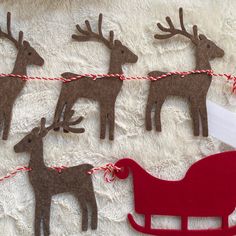 christmas decorations made to look like reindeers and sleigh on a white blanket