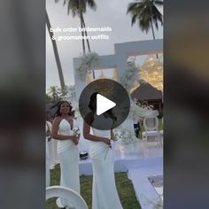 two women in white dresses standing next to each other at an outdoor event with palm trees