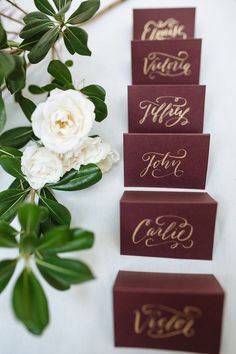 four place cards with gold lettering on them