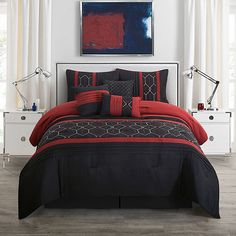 a bed with red and black comforters in a room