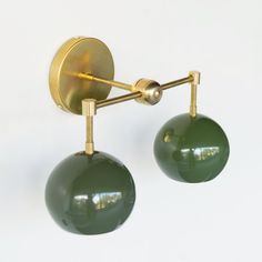 pair of green glass ball wall lights on gold plated metal arms, circa 1950's