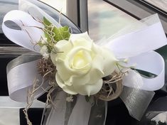 a white rose is tied to the side of a car