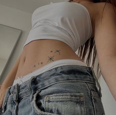 a woman's stomach with stars on it and a star tattoo on the side