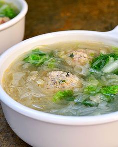 two white bowls filled with soup on top of a table