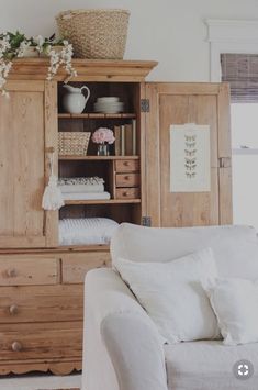 a white couch sitting in front of a wooden cabinet