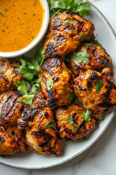 grilled chicken with garnish and dipping sauce on a plate