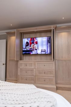 a flat screen tv sitting on top of a wooden entertainment center