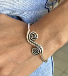 ❋ Sterling Silver Adjustable Rounded Engraved Bangle Bracelet With Spirals and Ethnic Symbolic Engraving Design ❋ Size: Adjustable, Medium -Large for women, Small- Medium for men ❋ The Length (end to end) is 6 7/8 - 17.5cm ❋ Wight: 0.65 ounces (about 18 grams) ❋ Metal Purity: 98% Pure Silver (Purer than sterling Silver - 92.5%) To browse some more of our Silver Jewelry collection you can click on the following links: https://www.etsy.com/shop/SilverShapes Earrings: https://www.etsy.com/shop/Silv Adjustable Bohemian Sterling Silver Bangle Bracelet, Handmade Bohemian Spiral Bracelets, Handmade Spiral Bohemian Bracelets, Traditional Adjustable Spiral Jewelry, Handmade Bohemian Spiral Bracelet, Bohemian Spiral Bracelet As A Gift, Handmade Adjustable Spiral Bracelets, Handmade Adjustable Spiral Bracelet, Silver Spiral Bohemian Bracelets