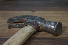 an old hammer is laying on top of a wooden table