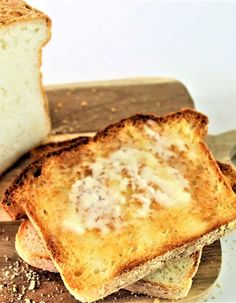 two pieces of bread sitting on top of a wooden cutting board next to each other