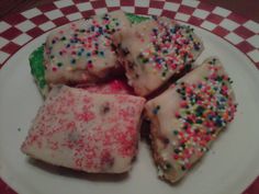 four pieces of cake with sprinkles on a white and red checkered plate