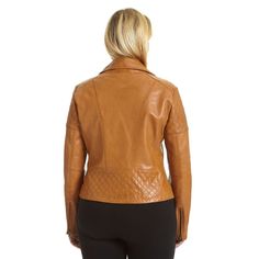 a woman wearing a tan leather jacket and black leggings, looking back at the camera