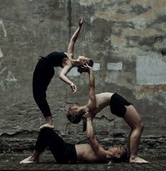 two people doing acrobatic tricks in front of a wall