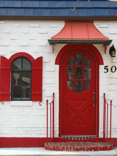 a red and white building with a red door