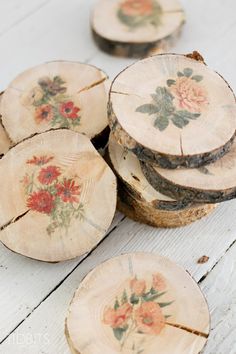 several pieces of wood with flowers painted on them are stacked next to eachother