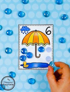 someone is holding an umbrella in front of some water droplets on a blue background with white polka dots