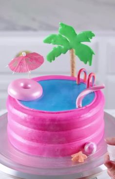 there is a cake that looks like a pool with an umbrella and flamingos on top