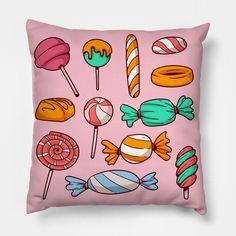 a pink pillow with candy and lollipops on it