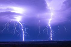 lightning strikes in the sky over an open field