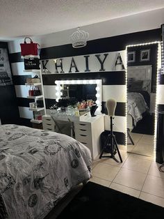 a bedroom decorated in black and white with lights on the headboard, dressers, mirror and bed