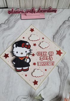 a hello kitty graduation cap with the class of 2020 written on it and red stars