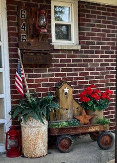 an old wagon with flowers in it is sitting on the side of a brick building