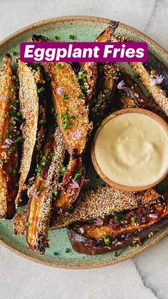 an eggplant fries on a plate with dipping sauce in the middle and breadcrumbs to the side