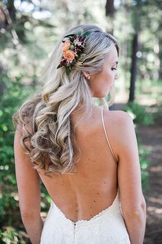 the back of a bride's dress with flowers in her hair