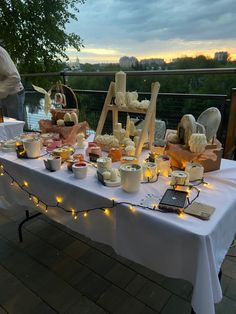 a table that has food on it and some lights strung up around the table in front of it