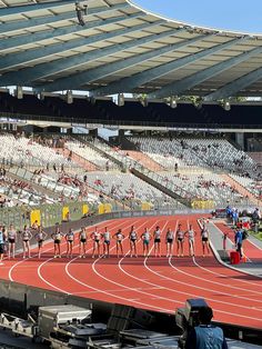 a group of people standing on top of a track next to an empty bleachers