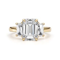 an emerald - cut diamond ring with three stone accents on the shoulders and side stones in yellow gold