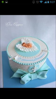 a blue and white cake with a baby's name on it, sitting on top of a blue mat