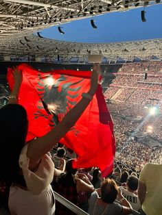 a woman holding up a red flag in front of an audience at a sporting event