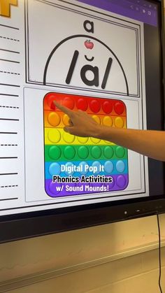 a person is pointing to a large screen with letters and numbers in front of them