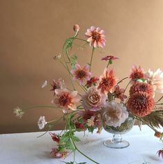 a vase filled with lots of flowers on top of a table