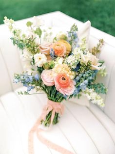 a bridal bouquet sitting on top of a white chair