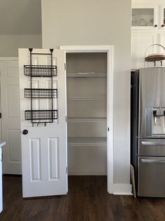 an open pantry door in a kitchen next to a refrigerator