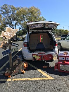 the back end of a minivan parked in a parking lot with its trunk open