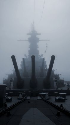 the battleship is surrounded by fog and birds on it's back deck, as seen from below